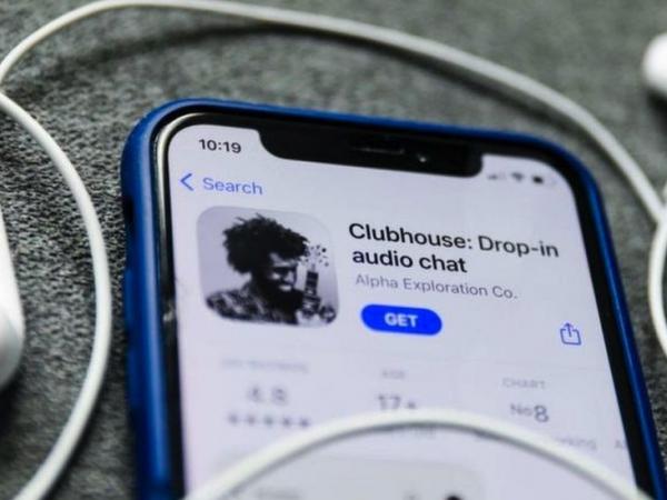BBC Mundo: Un iPhone con la aplicación Clubhouse abierta y un par de auriculares