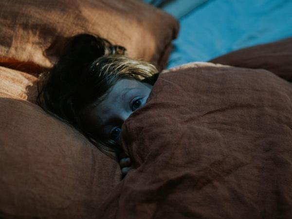 BBC Mundo: Una niña se cubre con el plumón de su cama.